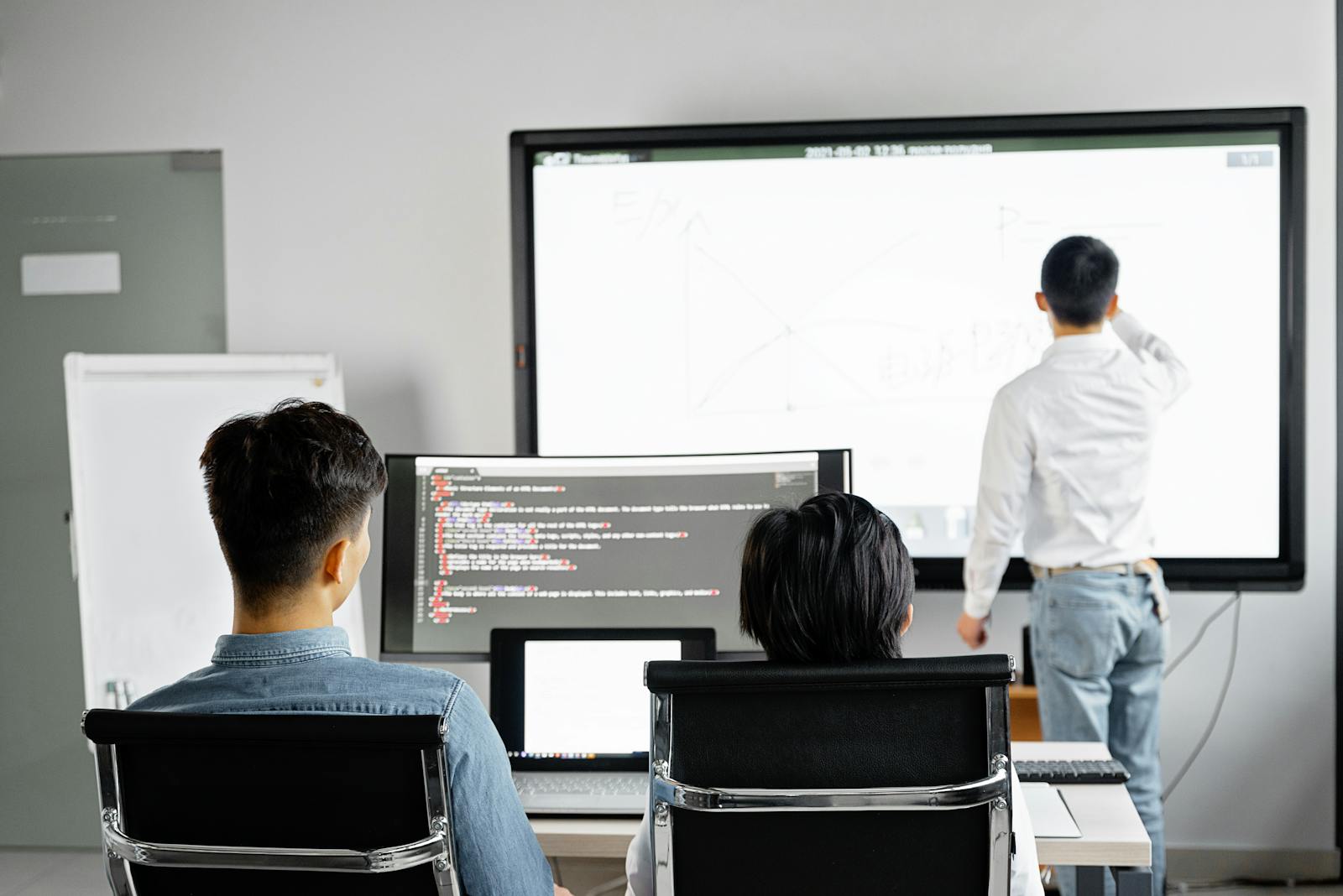 Équipe effectuant une présentation professionnelle à l'aide de la technologie dans un bureau moderne.