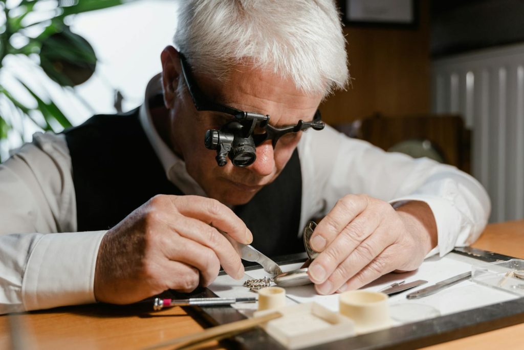 Un horloger répare méticuleusement une montre de poche avec des outils de précision et une loupe.